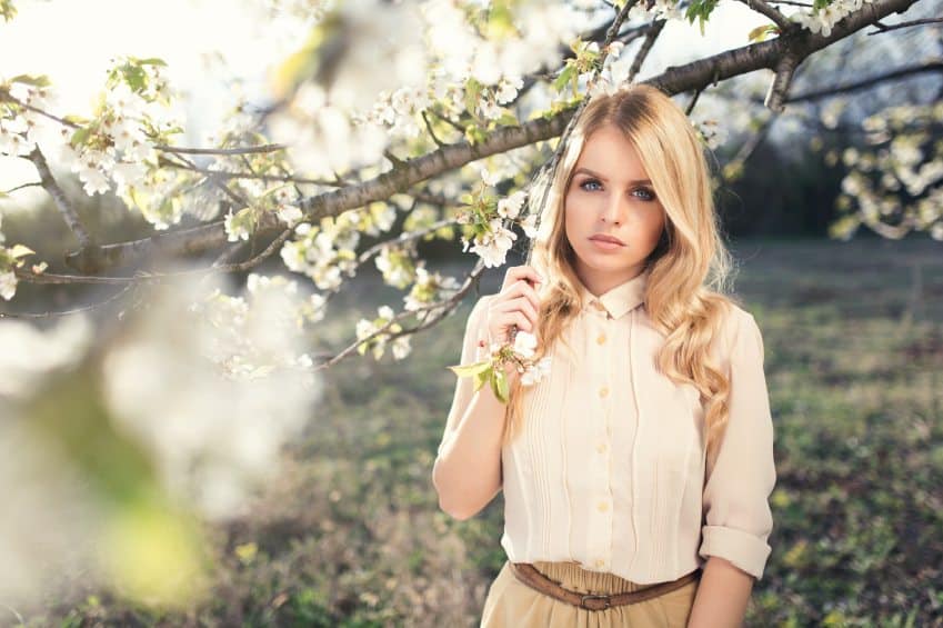 Blonde standing under tree