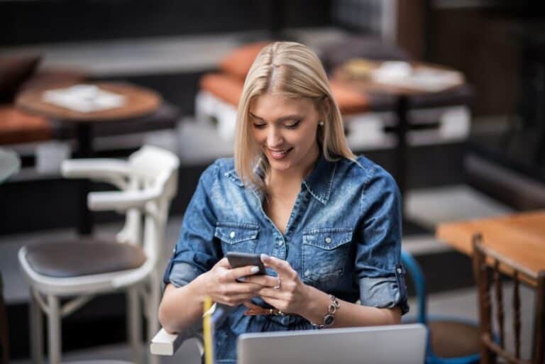 Blonde sitting looking at cellphone