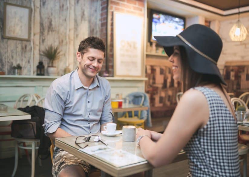 happy smiling couple enjoying coffee at cafe