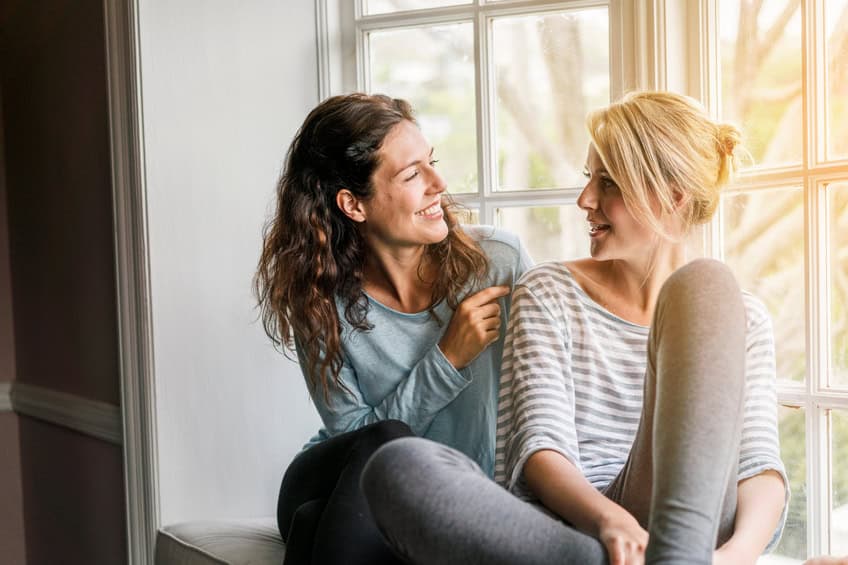 Two women talking window sill