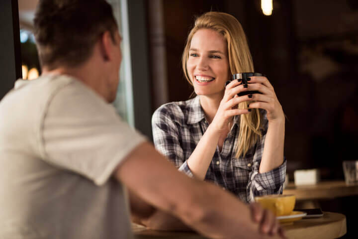couple smiling while drinking coffee