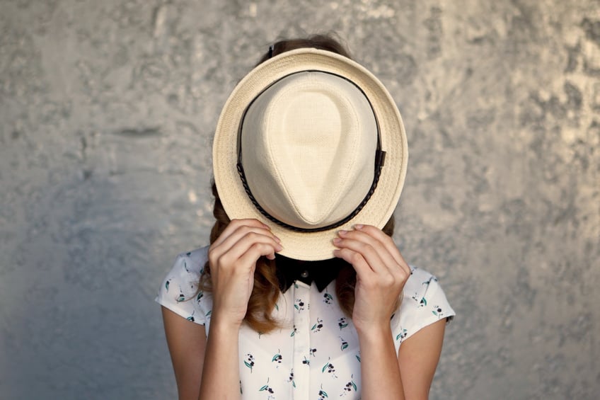 Young girl with hat. Hides her face