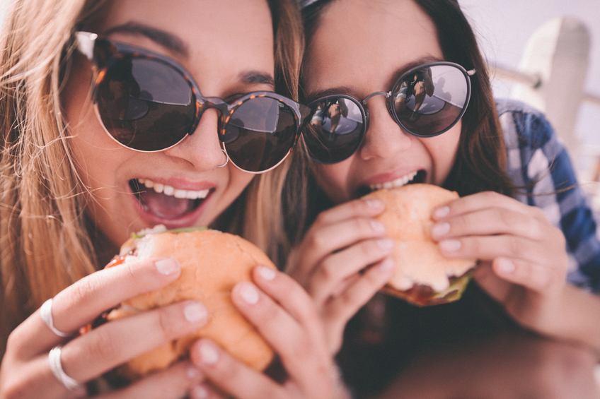Best friends eating burgers together.