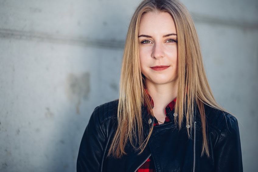 Portrait of young pretty girl standing on the street