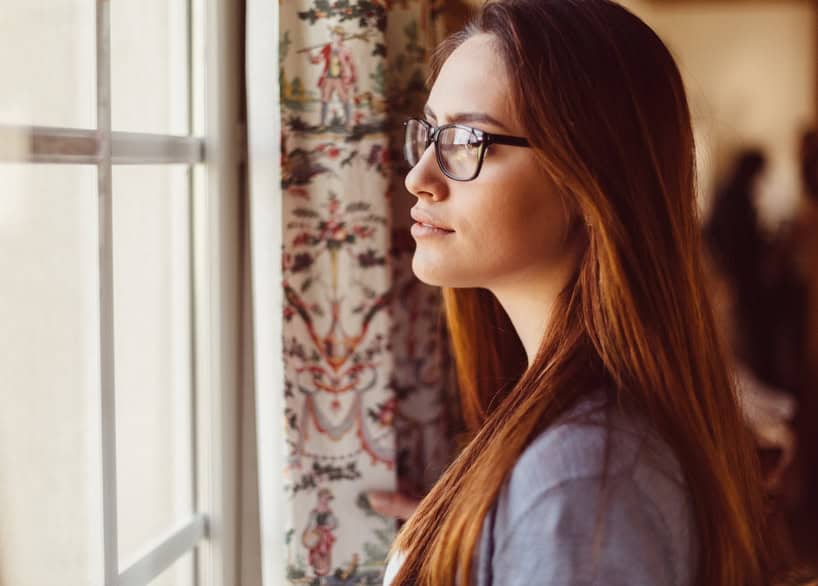 Young woman looking through the window