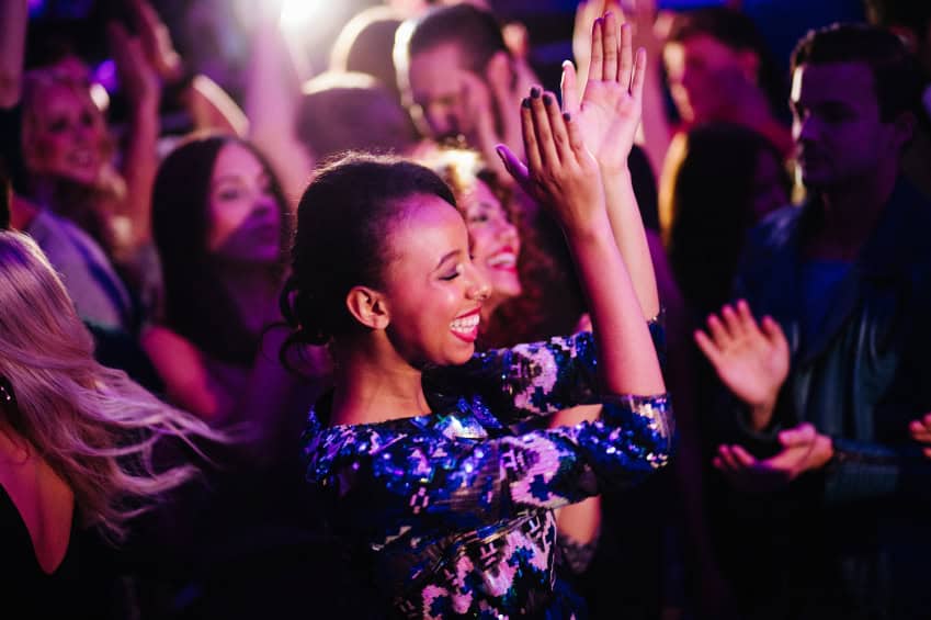 Woman at a party clapping and dancing.