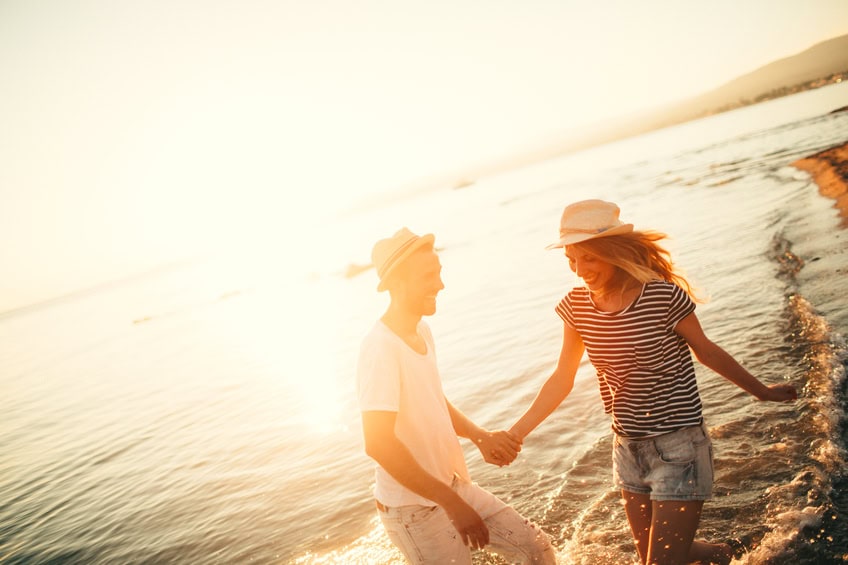 couple holding hands beach sunset