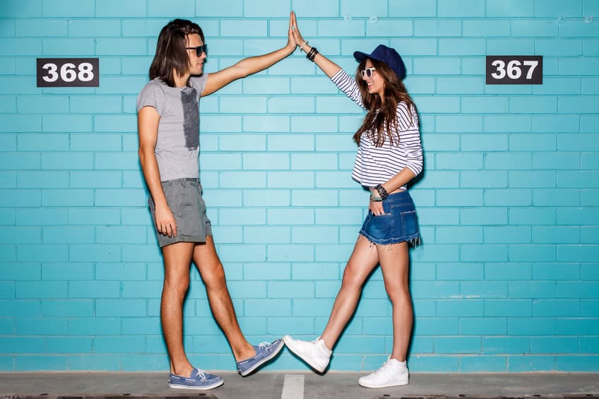 couple high five blue wall