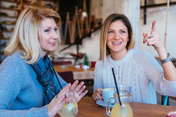 Mature and young woman having coffee time in modern cafe