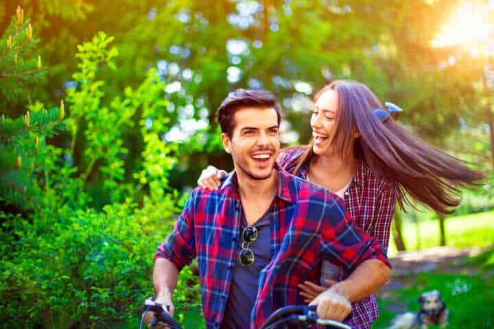 happy couple bike park green sun