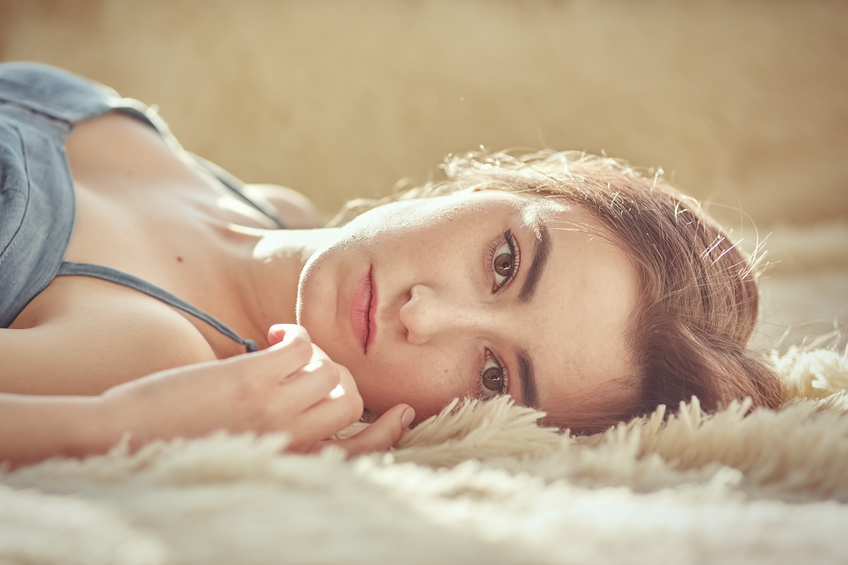 pensive girl lying looking at camera, toned image