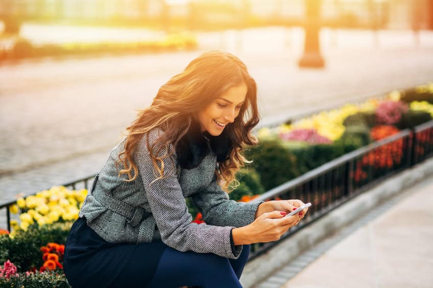 woman texting phone sunshine