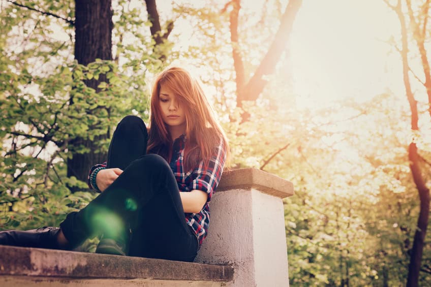 woman sitting high up on a wall