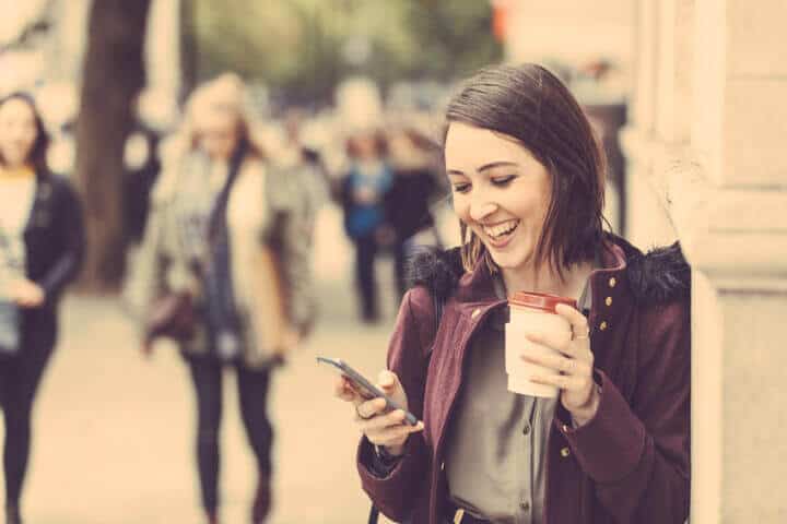 happy woman phone text outside autumn