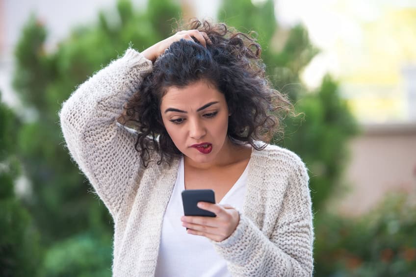Woman receiving bad news on smartphone