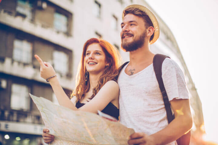 Young couple touring a foreign city, reading a map.