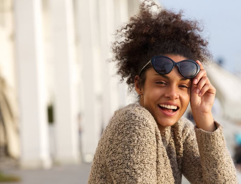 woman smiling happy outdoors sunglasses