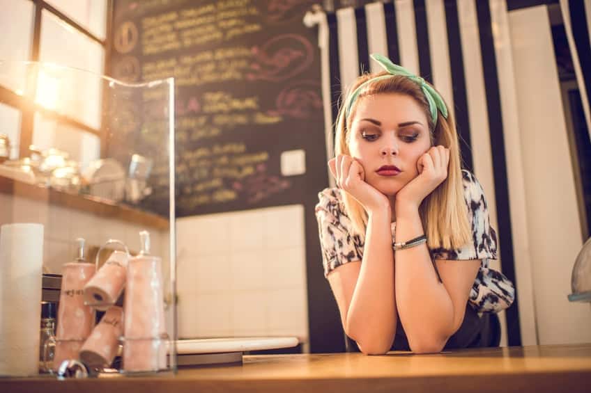Sad retro styled female worker waiting for her customers.