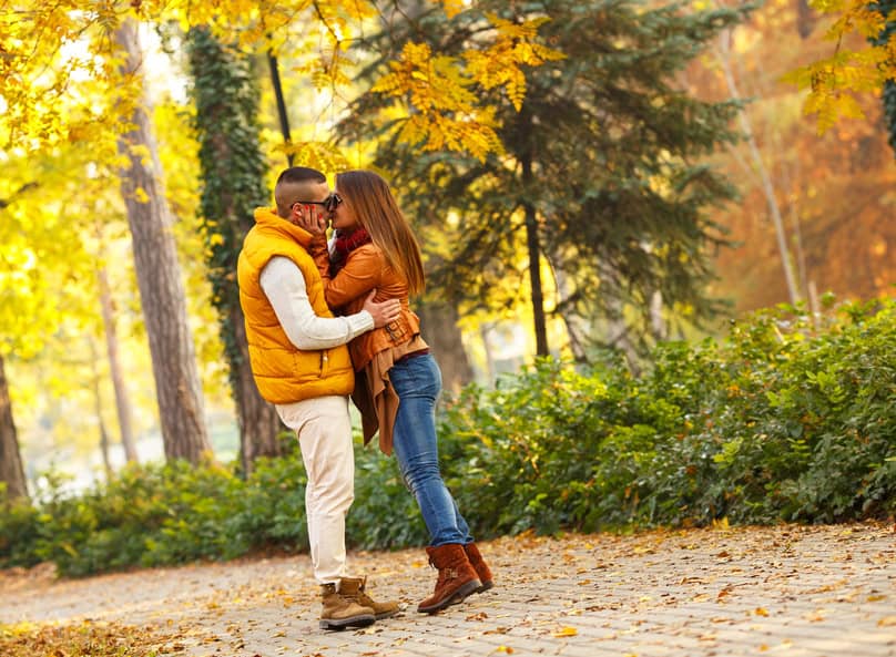 Young couple walking in the park on a sunny autumn day