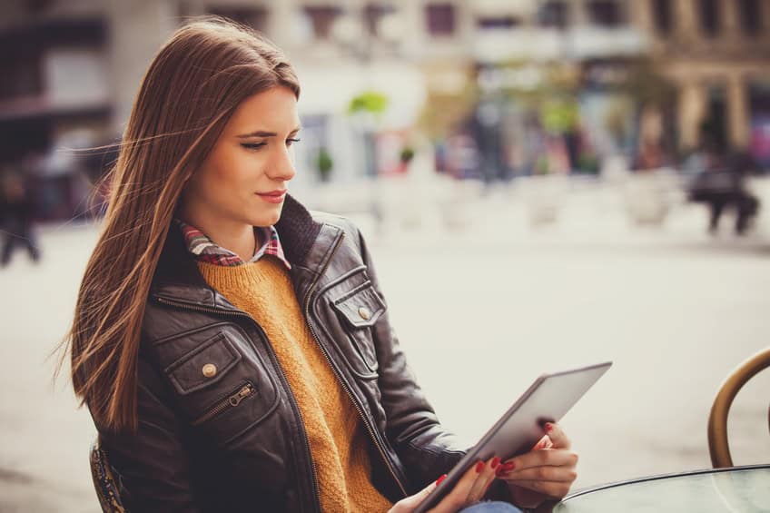 Young woman using digital tablet outside