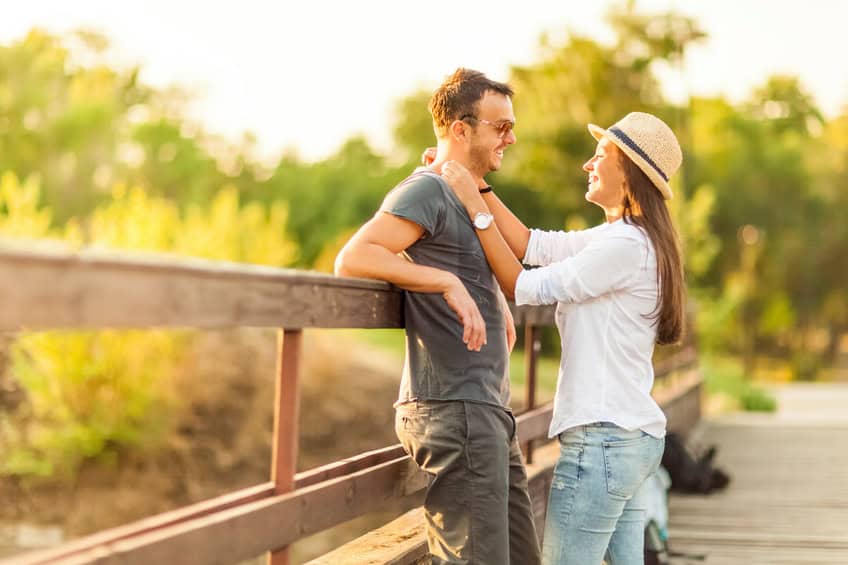 Backlit portrait of a young romantic couple outdoors, enjoying their time together.