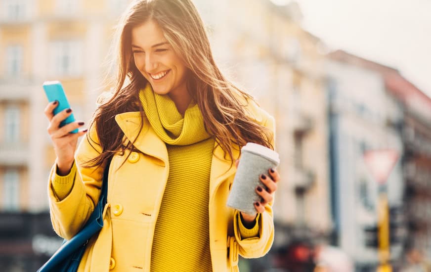 young woman happy smiling phone city coffee
