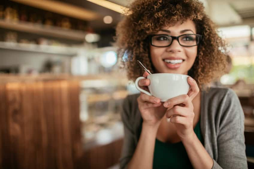 Photo of a young woman enjoying morning coffee in cafe