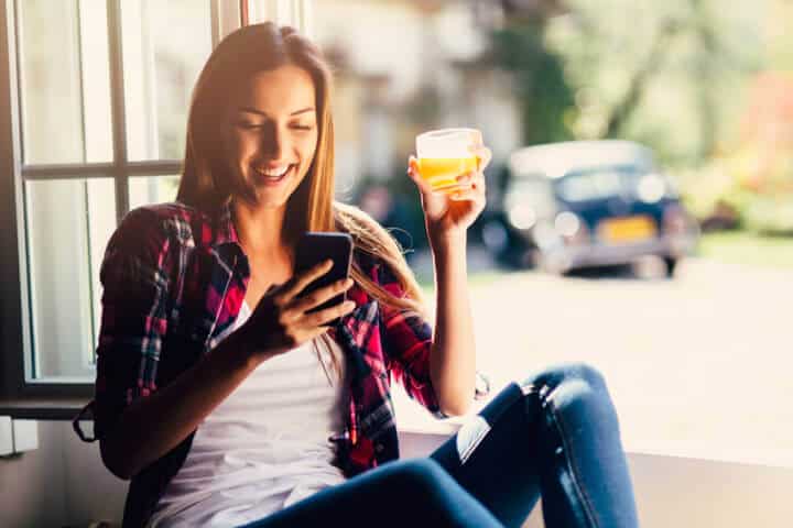 Beautiful young woman texting at home
