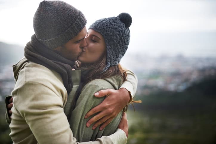 A young couple kissing outdoors