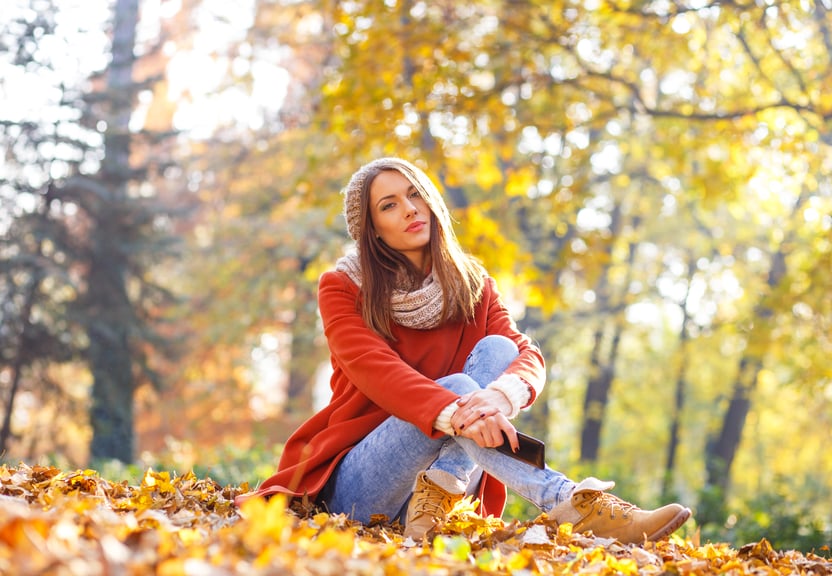 Young woman with smart phone relaxing in park
