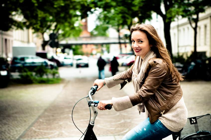woman riding bike city autumn