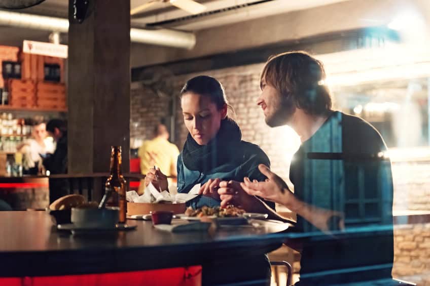 Young people in a club having drink and snack