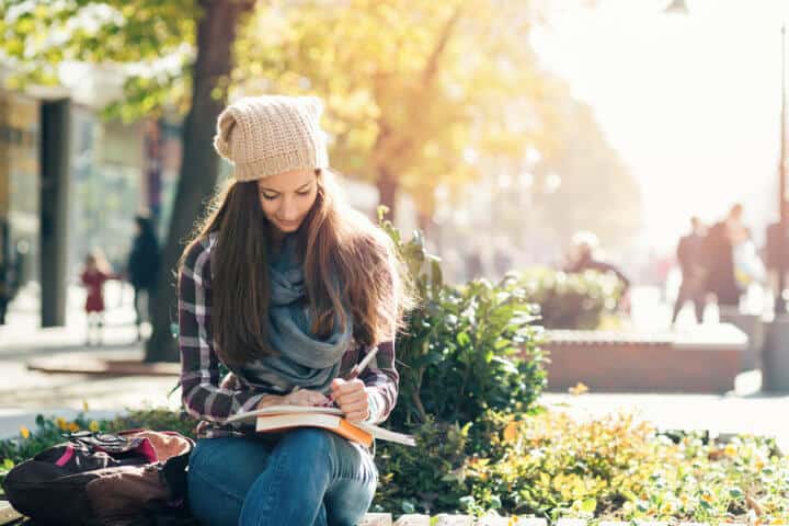 Girl writing in notebook and studying.