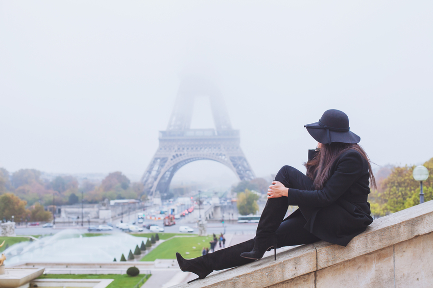 Woman looking at Eiffel Tower on a foggy day in Paris, France.