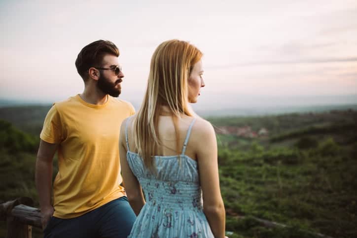 Young intimate couple on high viewpoint. Romantic landscape in front. Enjoying the view.
