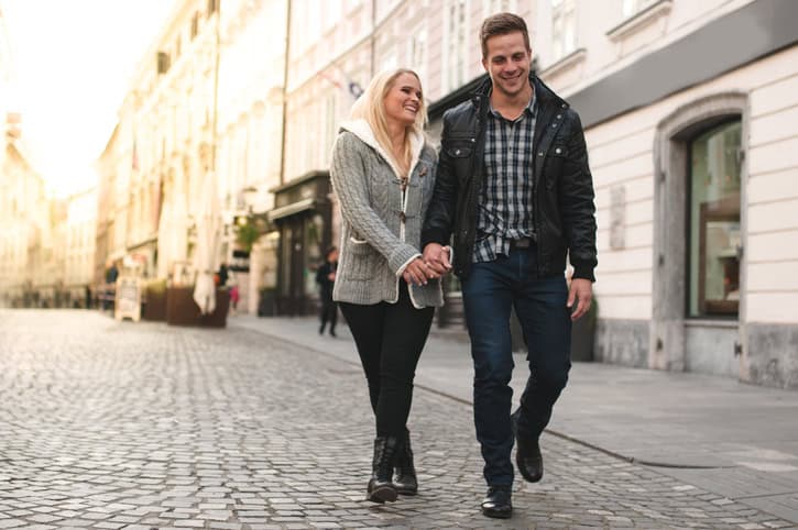 Young couple walking down the city street hand in hand