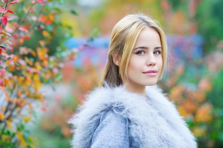 Portrait of a beautiful young woman in trendy outfit on autumn background