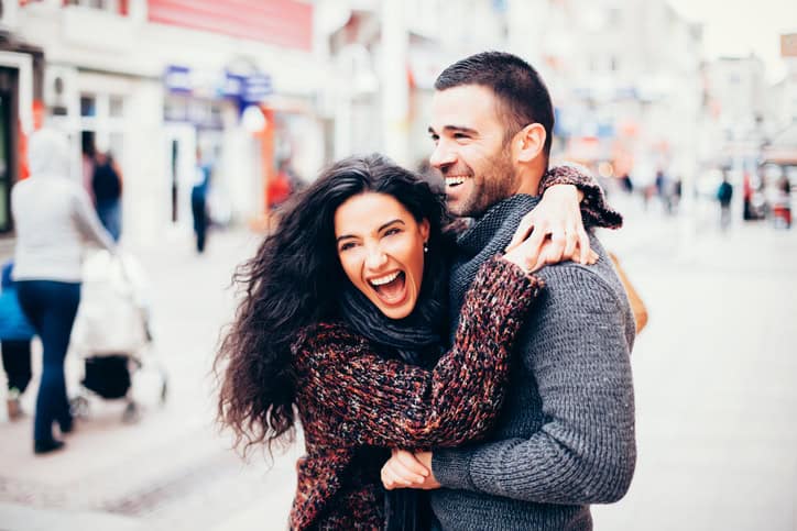 Young couple portrait laughing in the city