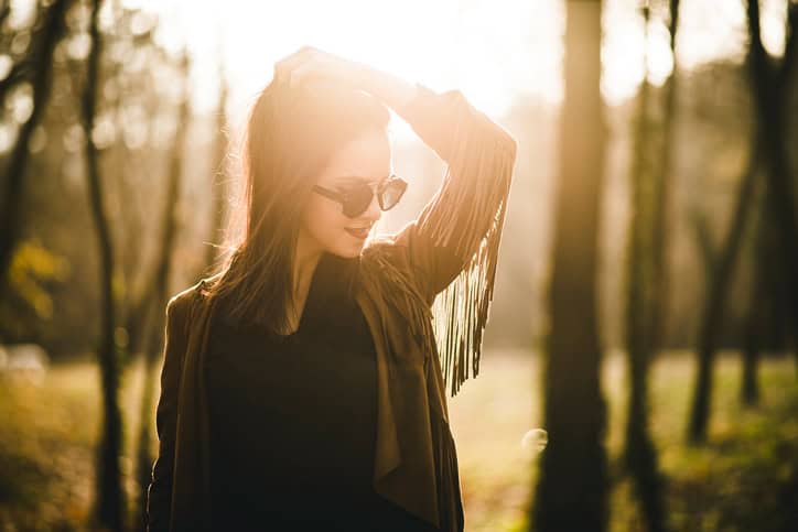 young woman happy forest sun portrait