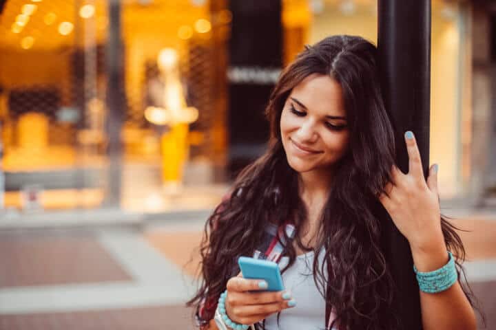 young woman texting sun outdoors