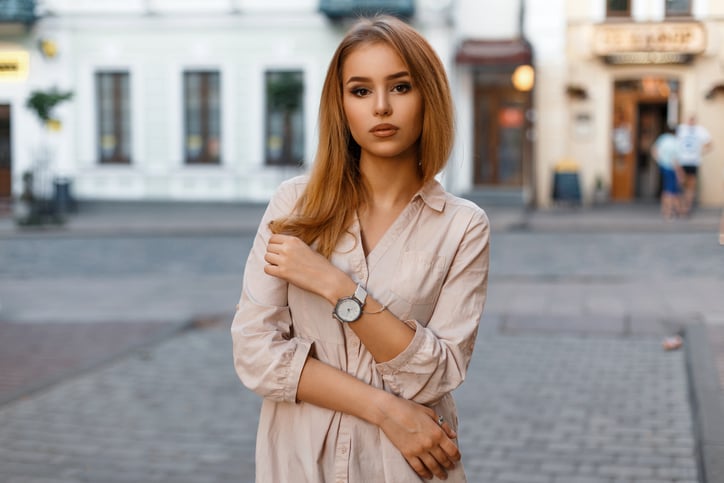 Stylish beautiful woman posing on a background of a building