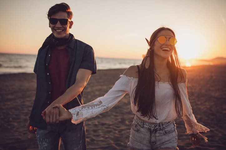 Love bird holding hands in the sunset on the beach