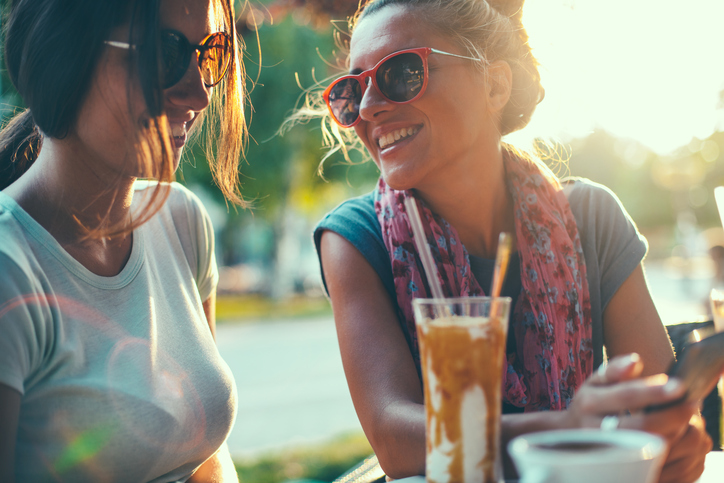 Female friends talking in cafe.
