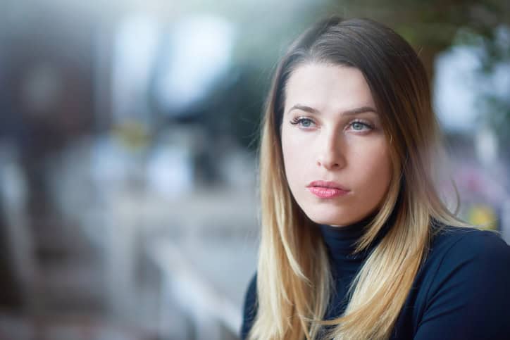 blond hair woman with blue eyes contemplating about life, looking away and feeling nostalgic.