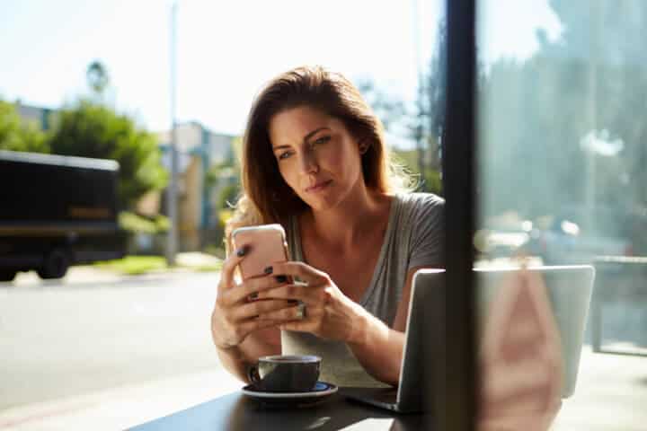 young woman texting sun outdoors