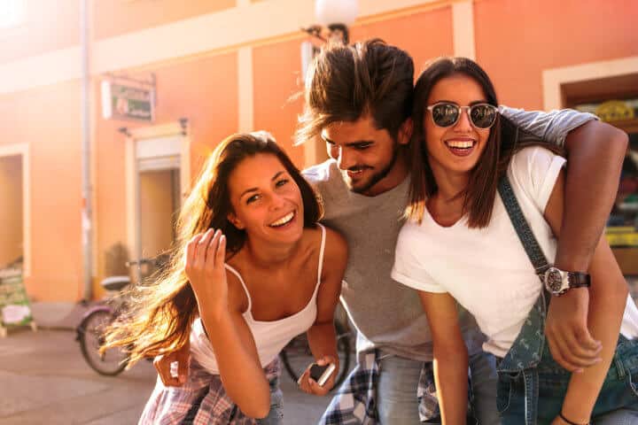 Group of happy young friends having fun on city street.Sunset.Close up image.
