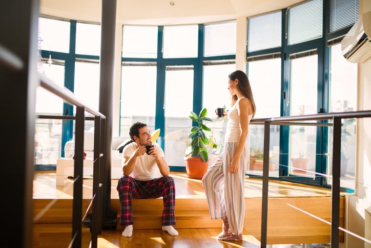 Affectionate couple is spending a weekend at home enjoying morning coffee and flirting.