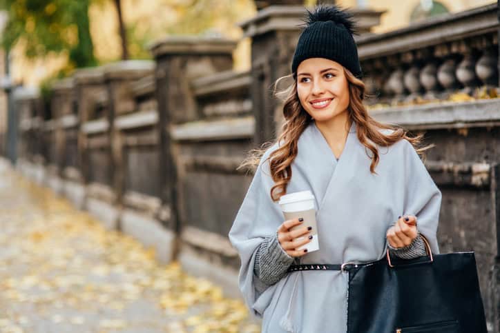 Young woman drinking coffee outdoors.