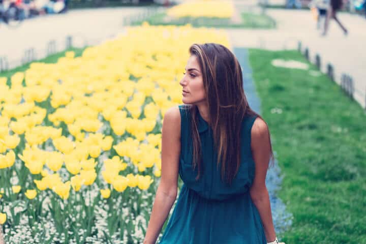 young woman look flowers garden
