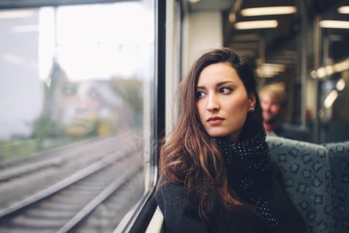 Vintage toned portrait of a young brunette woman riding in the Berlin S-bahn metro train. Only natural light used and some film emulation processing, taken on a late Autumn day in the afternoon.